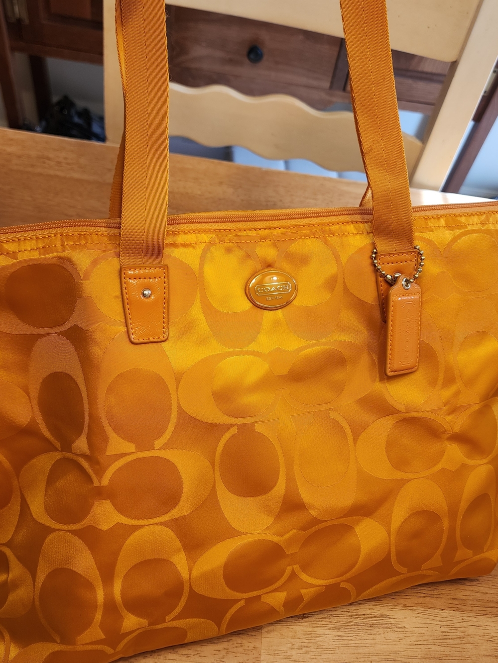 Coach Signature Nylon Leather tote bag in a vibrant orange-yellow color